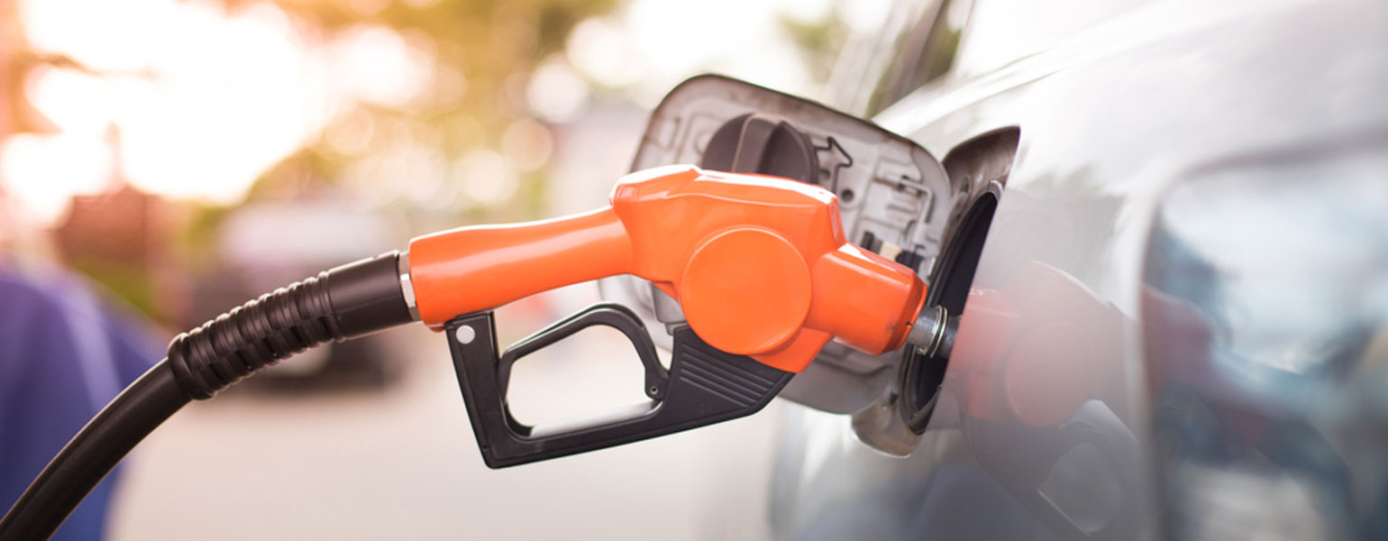 Gasoline nozzle in a car, pumping gas.