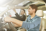 Car dealer and car buyer sitting in car