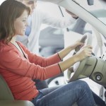 Woman sitting in car at dealership